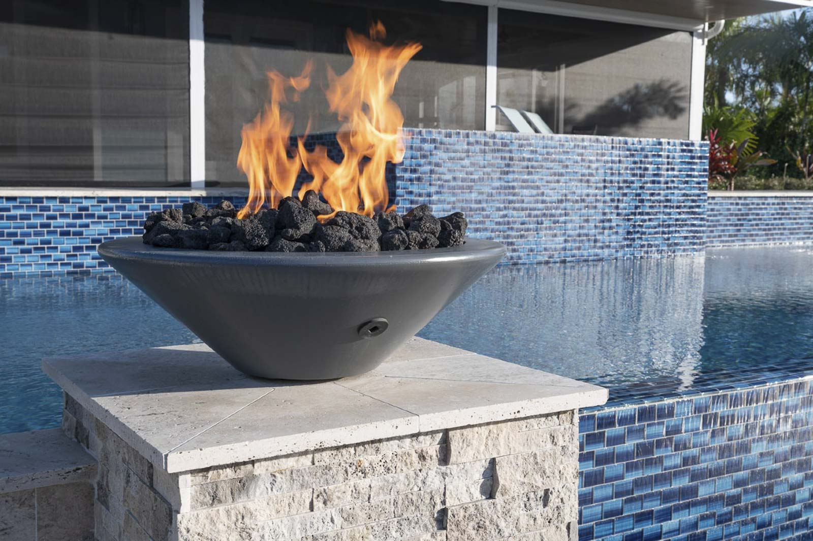 Pool area with elegant fire bowls and dramatic lighting design