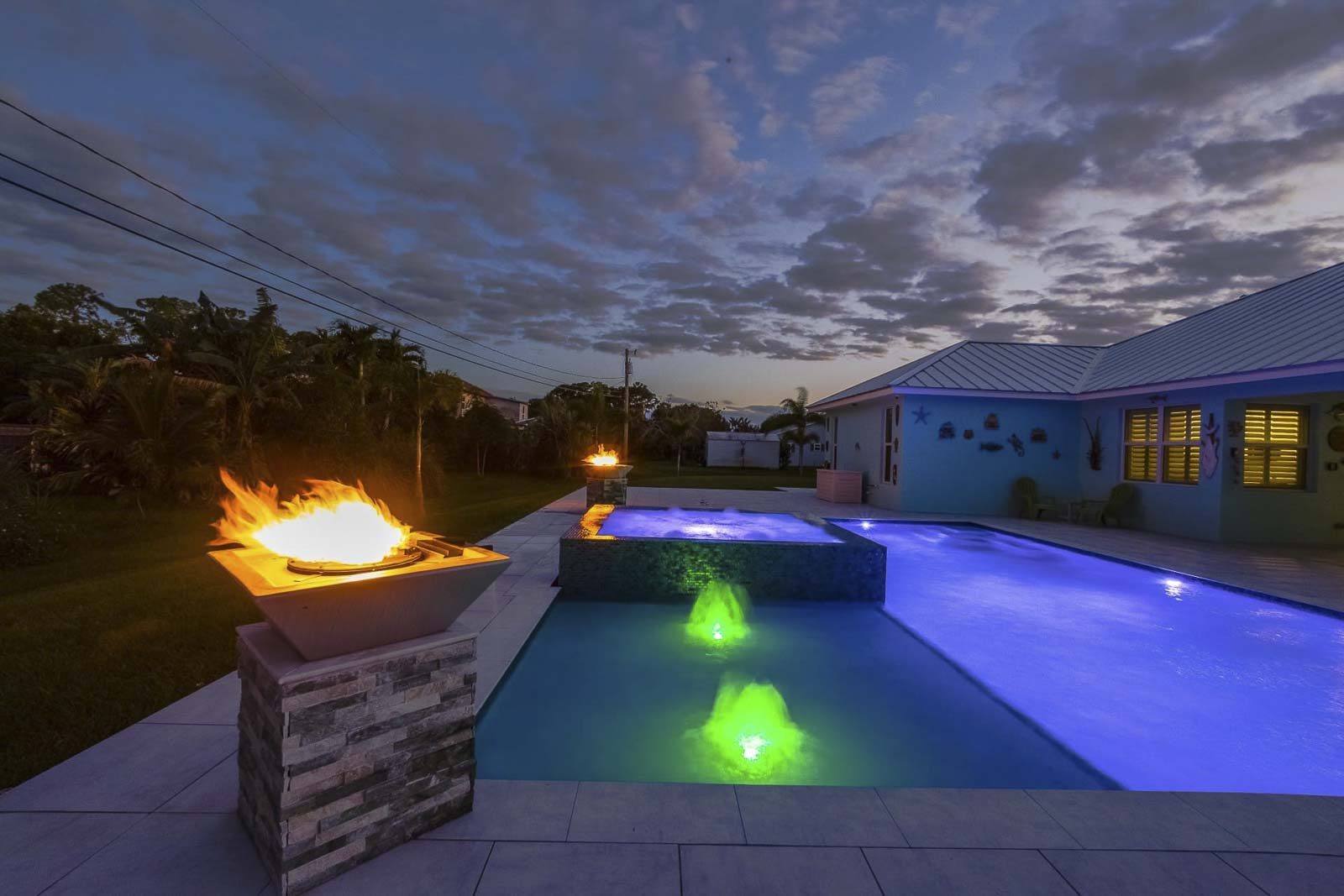 Pool with colorful LED lighting system creating nighttime ambiance in Palm Beach, Florida
