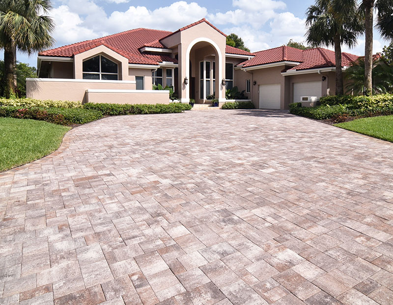 Custom rectangular paver driveway with beige home.